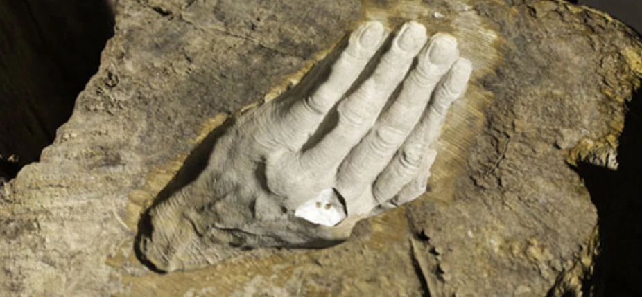 "Essero vento" : pour la première fois, le couple de grains de sable prend place dans l’empreinte de cette main inscrite dans un tronc fossilisé devenu minéral au fil du temps. Cette image est issue de la présentation de l’exposition "A Question of Identi
